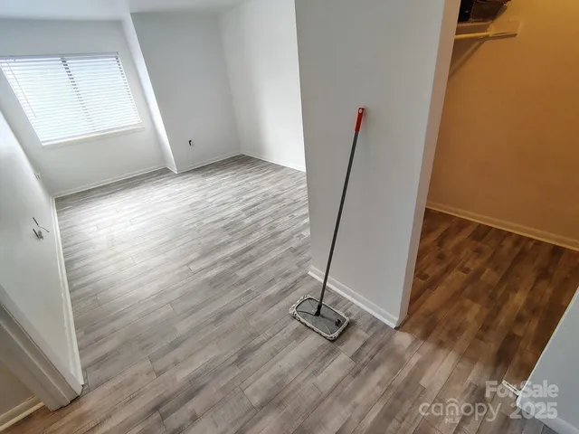a view of a room with wooden floor and white walls