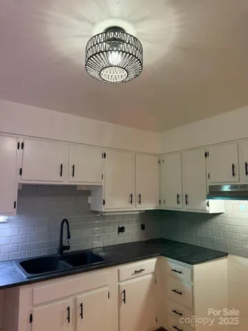 a kitchen with stainless steel appliances granite countertop a sink a stove and cabinets