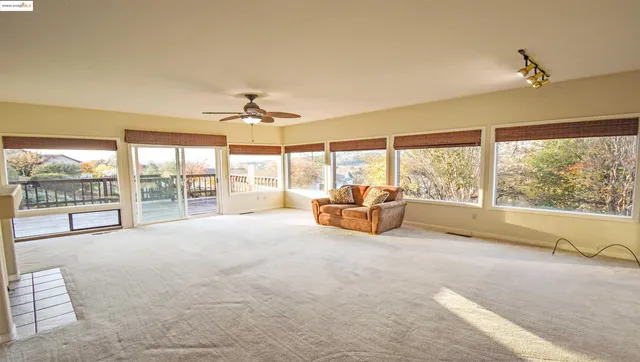 a living room with furniture and a large window with garden view