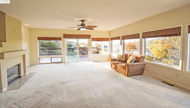 a living room with fireplace furniture and a large window