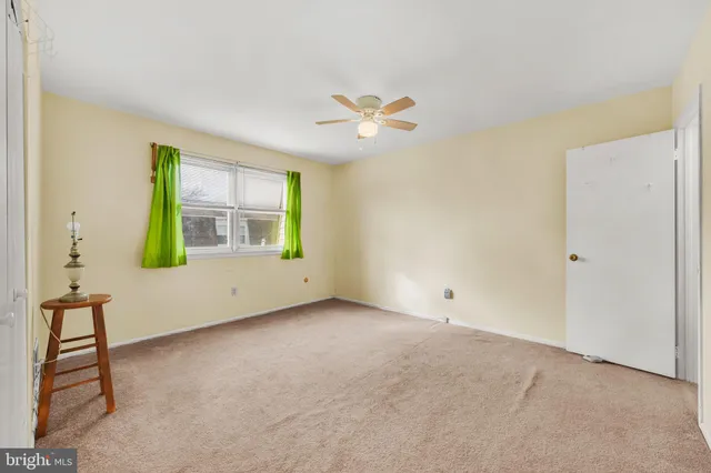 an empty room with windows and ceiling fan view