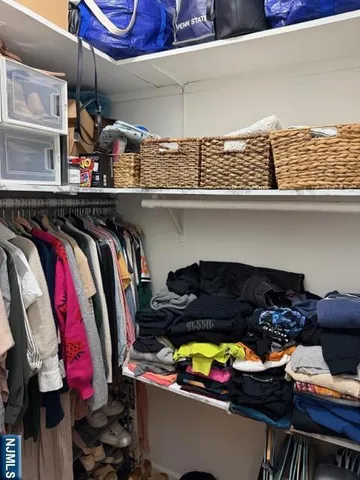 a view of walk in closet with clothes and shoes