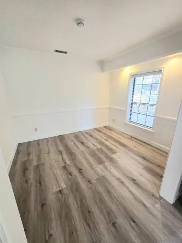 a view of a room with wooden floor and windows