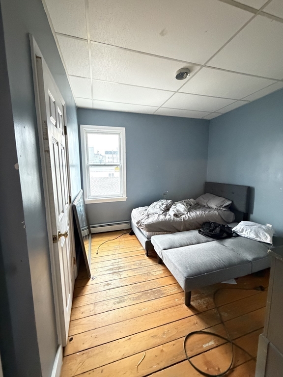 582 Cambridge Street Fall River, MA 02721 - Photo 15 of 19 a bedroom with a bed and wooden floor