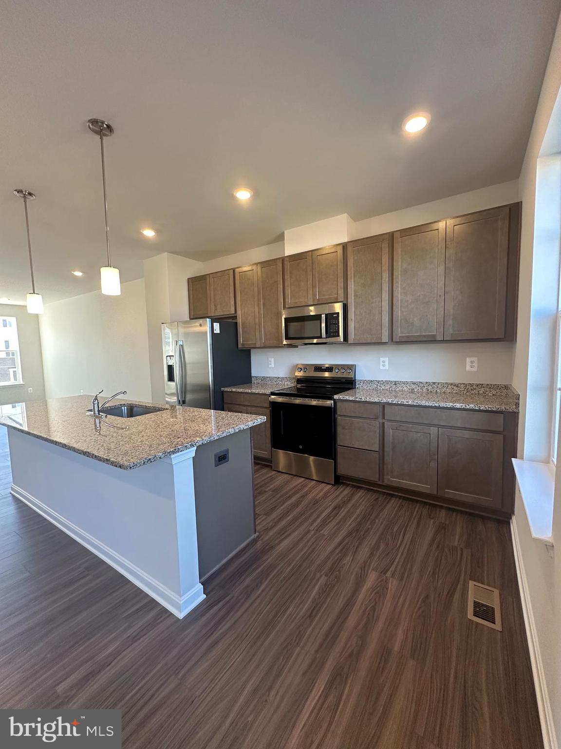149 Telluride Way Charles Town, WV 25414 - Photo 11 of 39 a kitchen with stainless steel appliances kitchen island granite countertop wooden floors and white cabinets