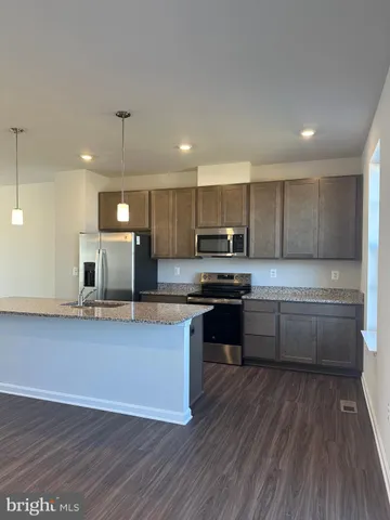 a kitchen with stainless steel appliances wooden floors and wooden cabinets