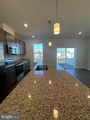 a kitchen with granite countertop a stove a sink and a granite counter top