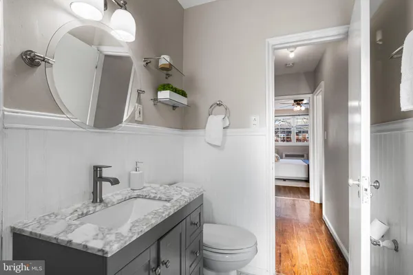 a bathroom with a granite countertop sink a toilet and a mirror