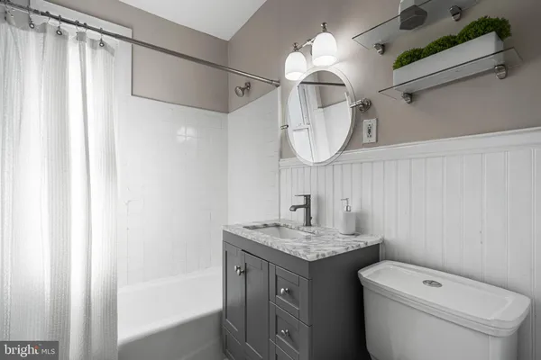 a bathroom with a granite countertop sink a toilet and a mirror