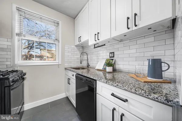a kitchen with granite countertop a sink stainless steel appliances and cabinets