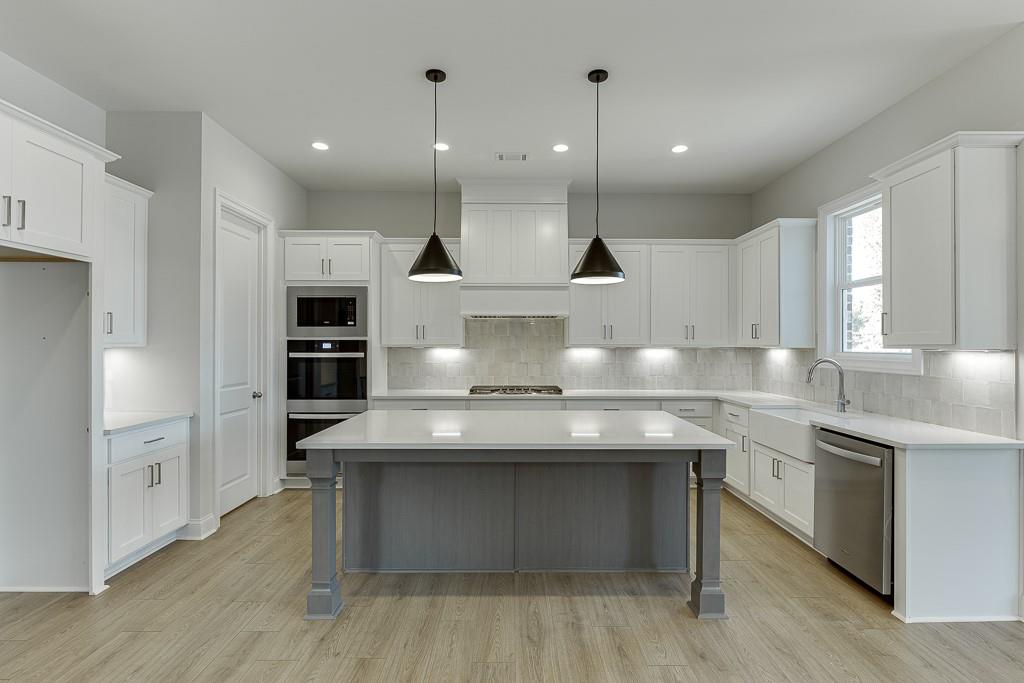 452 Thunder Road Buford, GA 30518 - Photo 15 of 80 a kitchen with kitchen island a sink appliances and cabinets