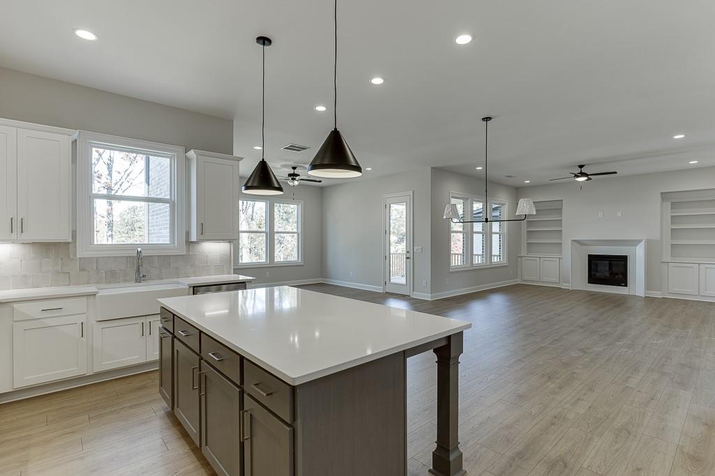 452 Thunder Road Buford, GA 30518 - Photo 19 of 80 a kitchen with kitchen island a sink stainless steel appliances and a chandelier
