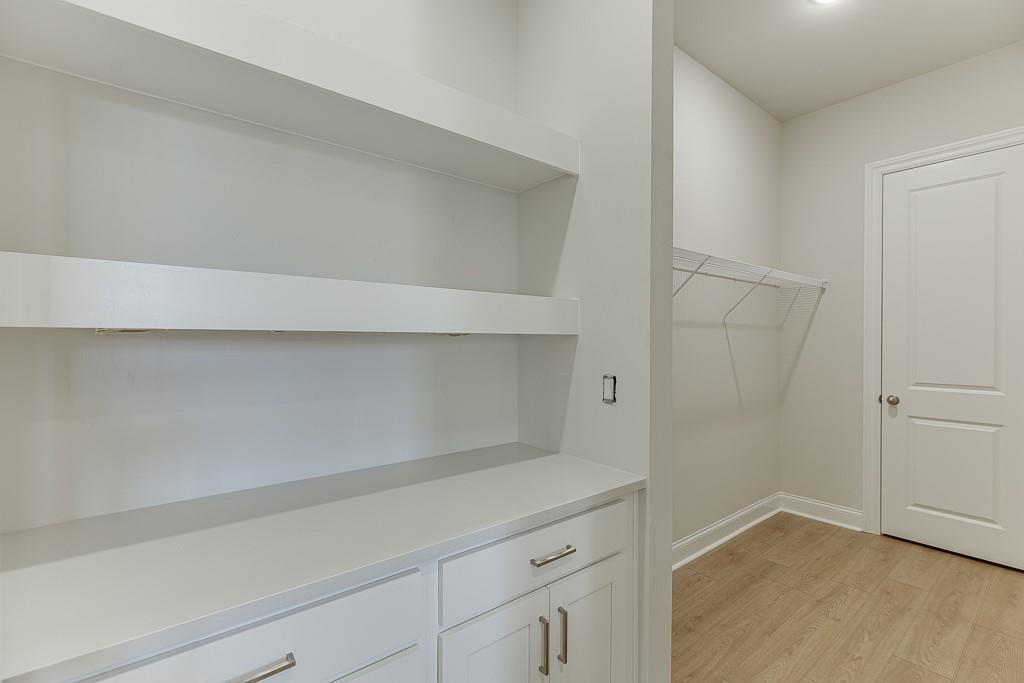 452 Thunder Road Buford, GA 30518 - Photo 24 of 80 a kitchen with a white cabinets and a wooden floor