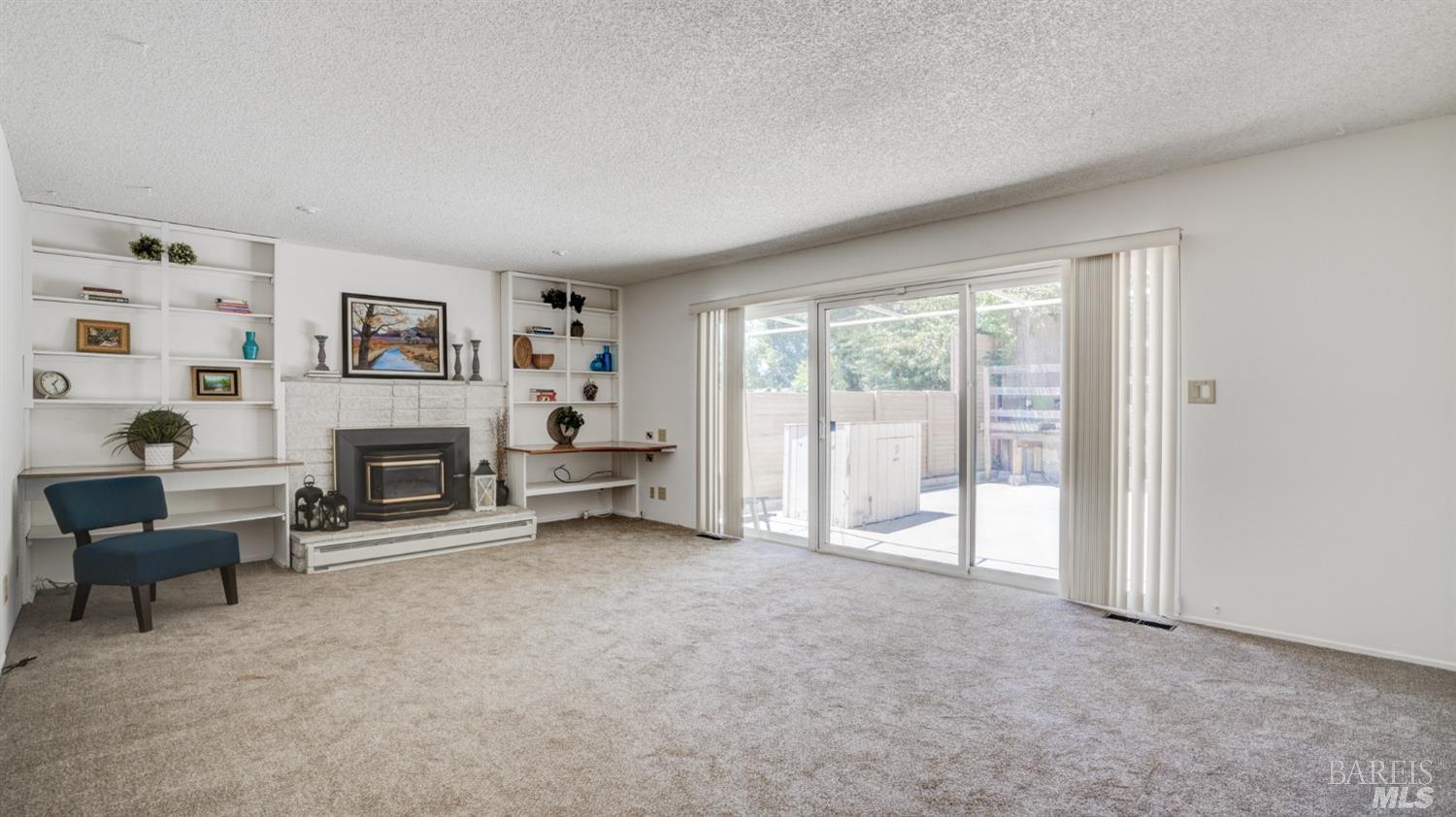 a living room with furniture a fireplace and a large window