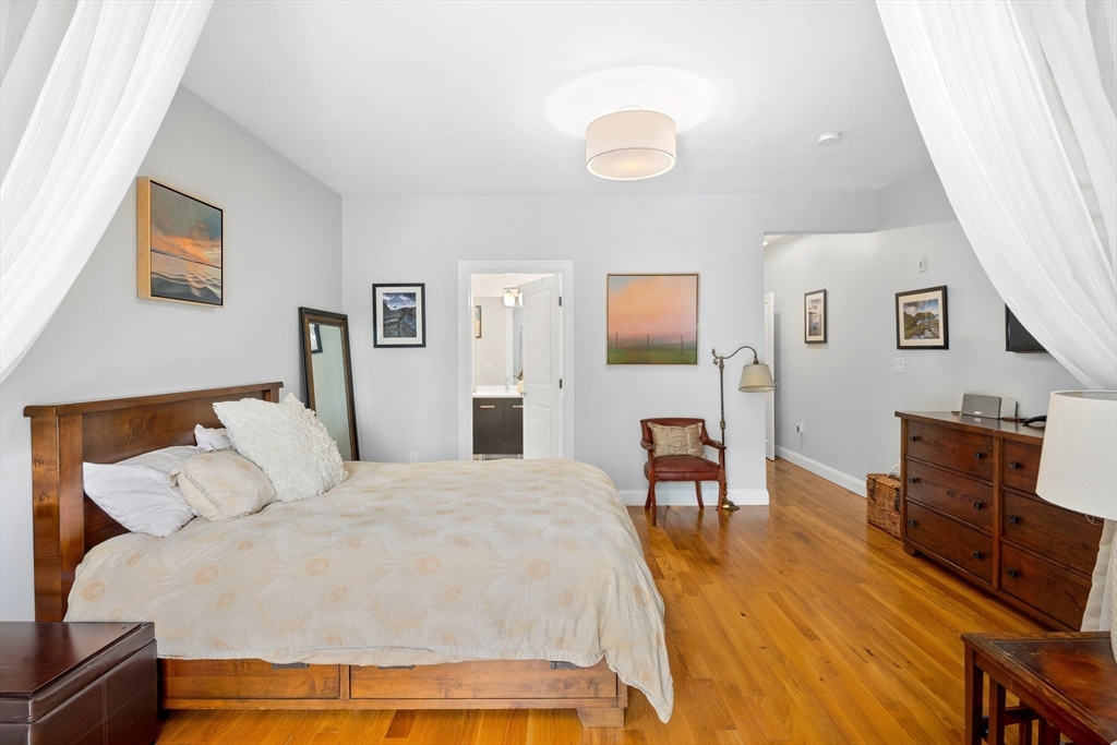 299 Sumner Street, Unit 1 Boston, MA 02128 - Photo 12 of 23 a bedroom with a bed and wooden floor