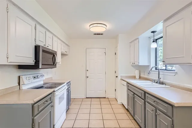 a kitchen with a sink stove and cabinets