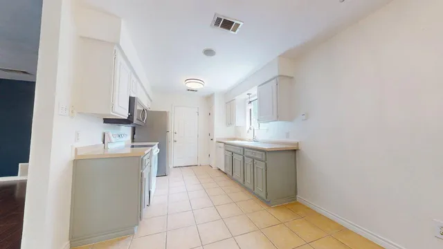 a kitchen with stainless steel appliances a sink stove and cabinets
