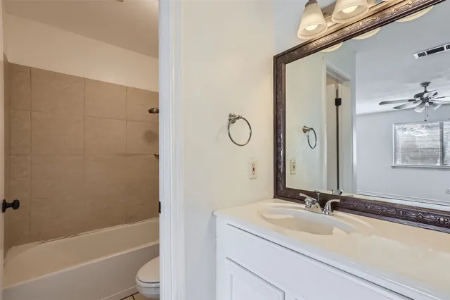 a bathroom with a sink a toilet and a large mirror