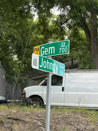 a view of a street sign under a large tree