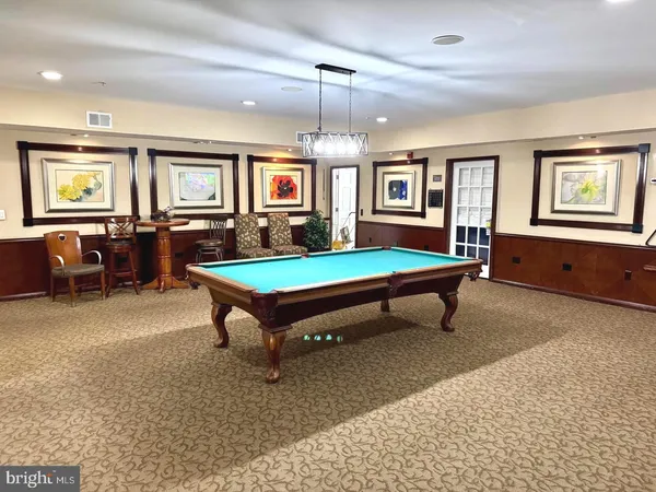 a living room with furniture pool table and a window