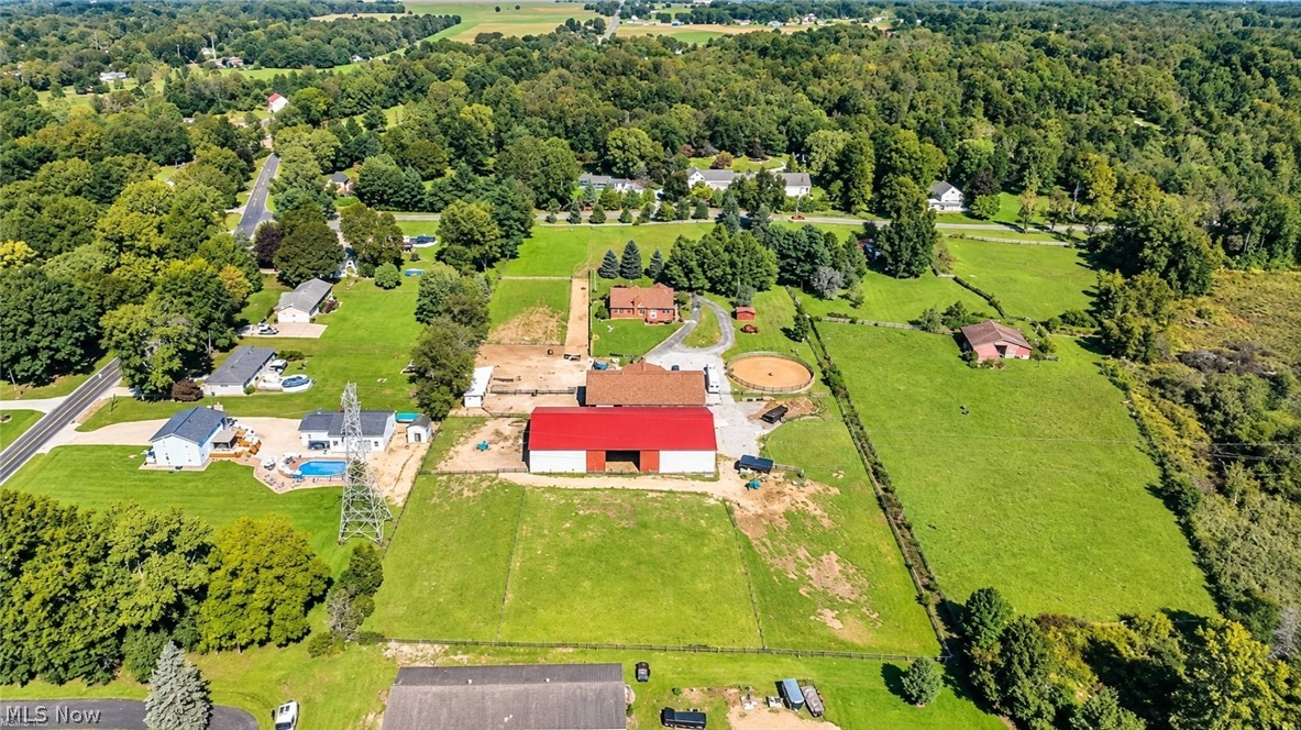 18 Manning Road Mogadore, OH 44260 - Photo 9 of 47 Expansive property featuring multiple structures, a large red-roofed barn, a circular riding arena, and a pool