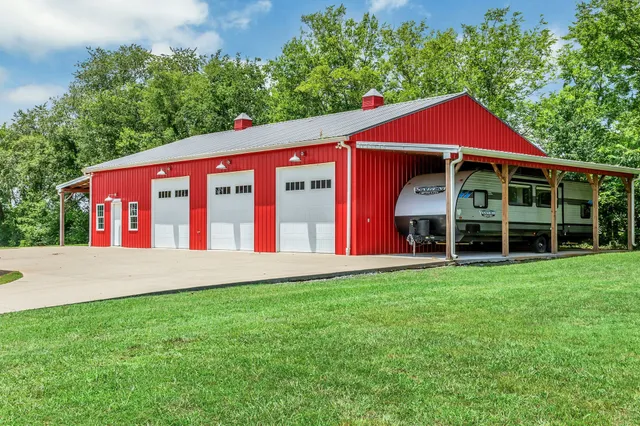 an empty room with wooden floor chandelier fan and windows