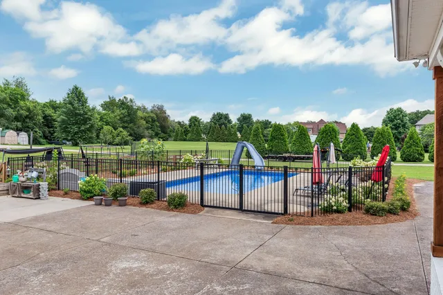 an empty room with wooden floor and a kitchen