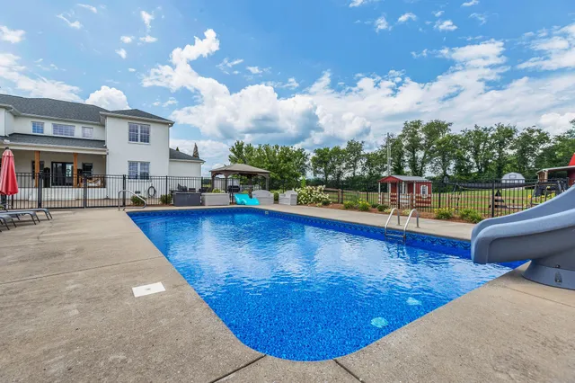 a large kitchen with granite countertop a large counter top space a sink stainless steel appliances and cabinets