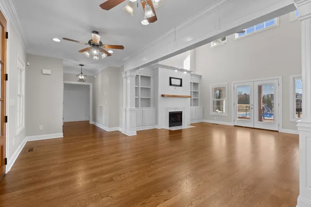 an empty room with wooden floor and windows