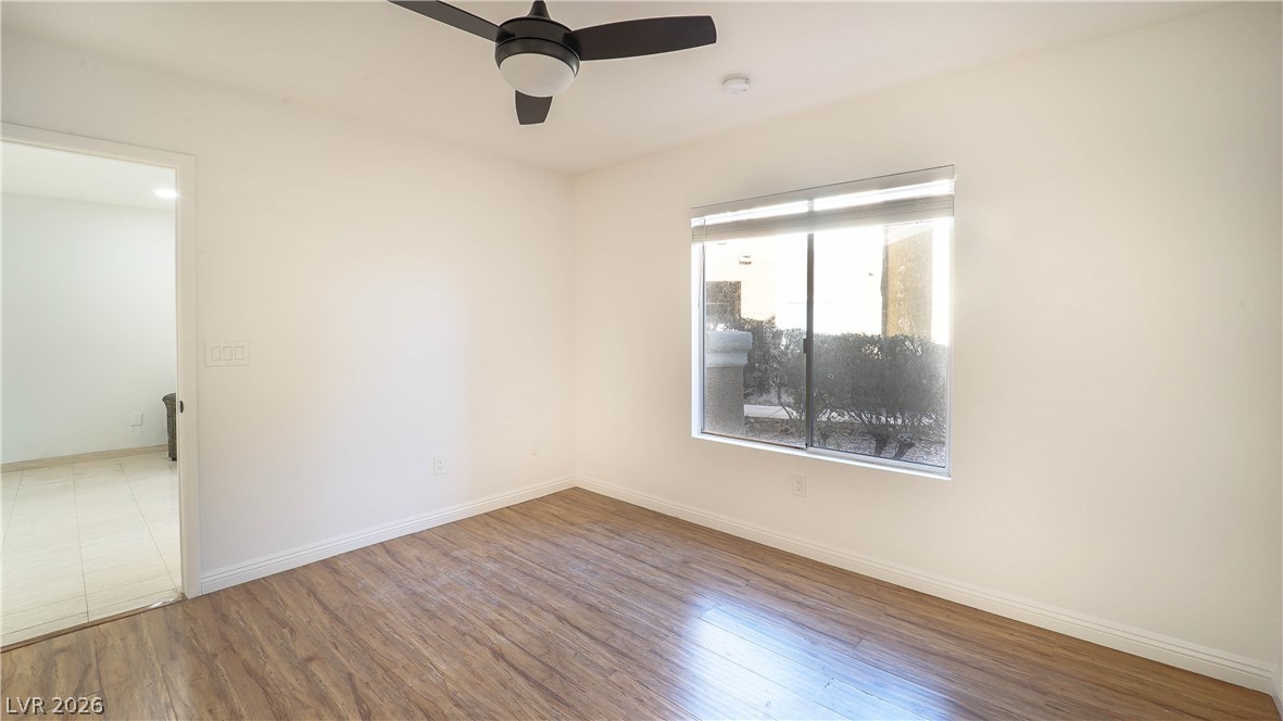 8070 West Russell Road, Unit 1099 Las Vegas, NV 89113 - Photo 16 of 31 A quiet bedroom showcases light wood flooring and a modern ceiling fan, offering a serene personal space.