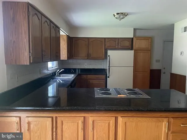 a kitchen with a refrigerator and a stove top oven
