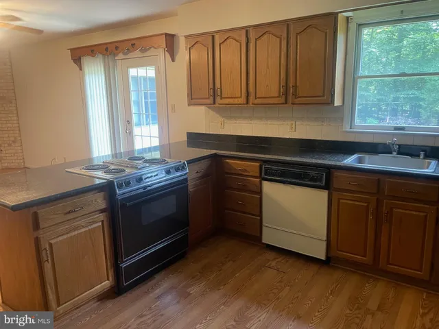 a kitchen with granite countertop cabinets stainless steel appliances and a window