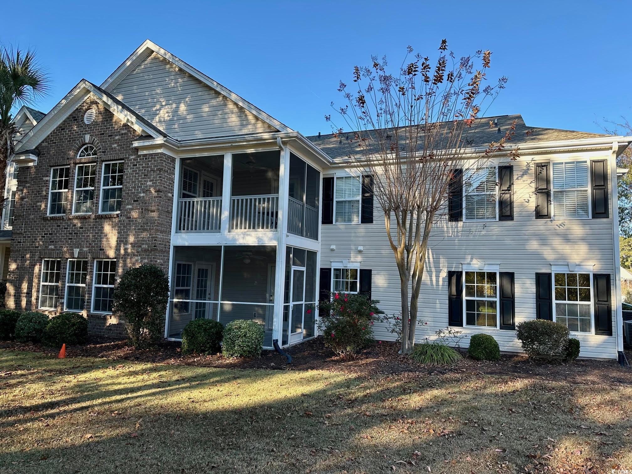 9 Pistachio Loop, Unit D Murrells Inlet, SC 29576 - Photo 20 of 21 Rear view of property with a sunroom, a lawn, and brick siding