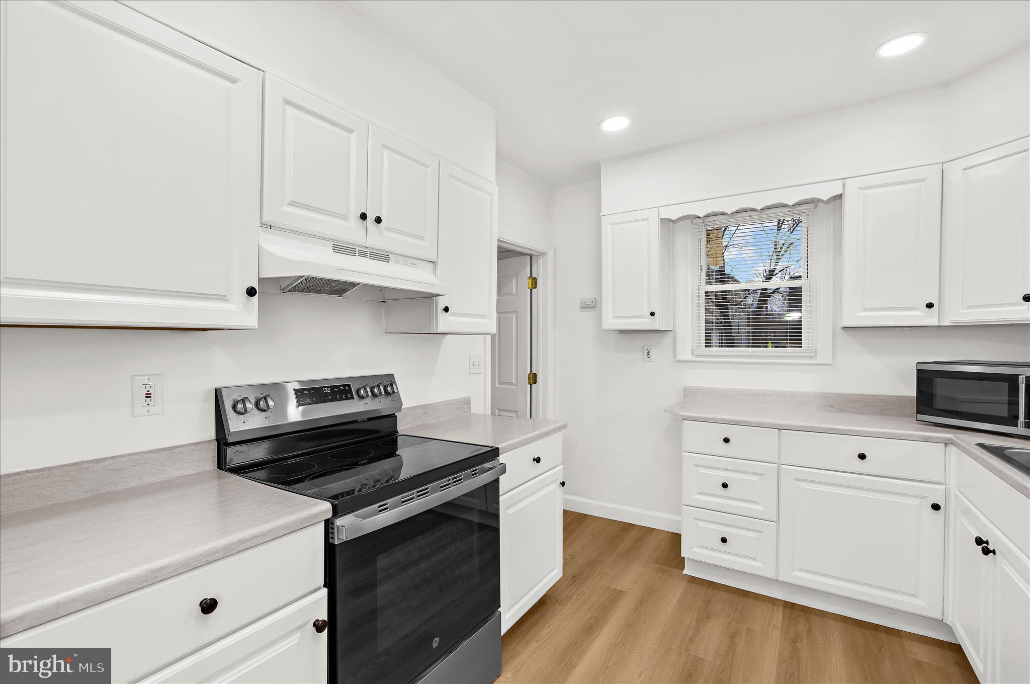 5701 Magie Street Baltimore, MD 21225 - Photo 15 of 49 a kitchen with stainless steel appliances white cabinets and a stove a oven with white countertops
