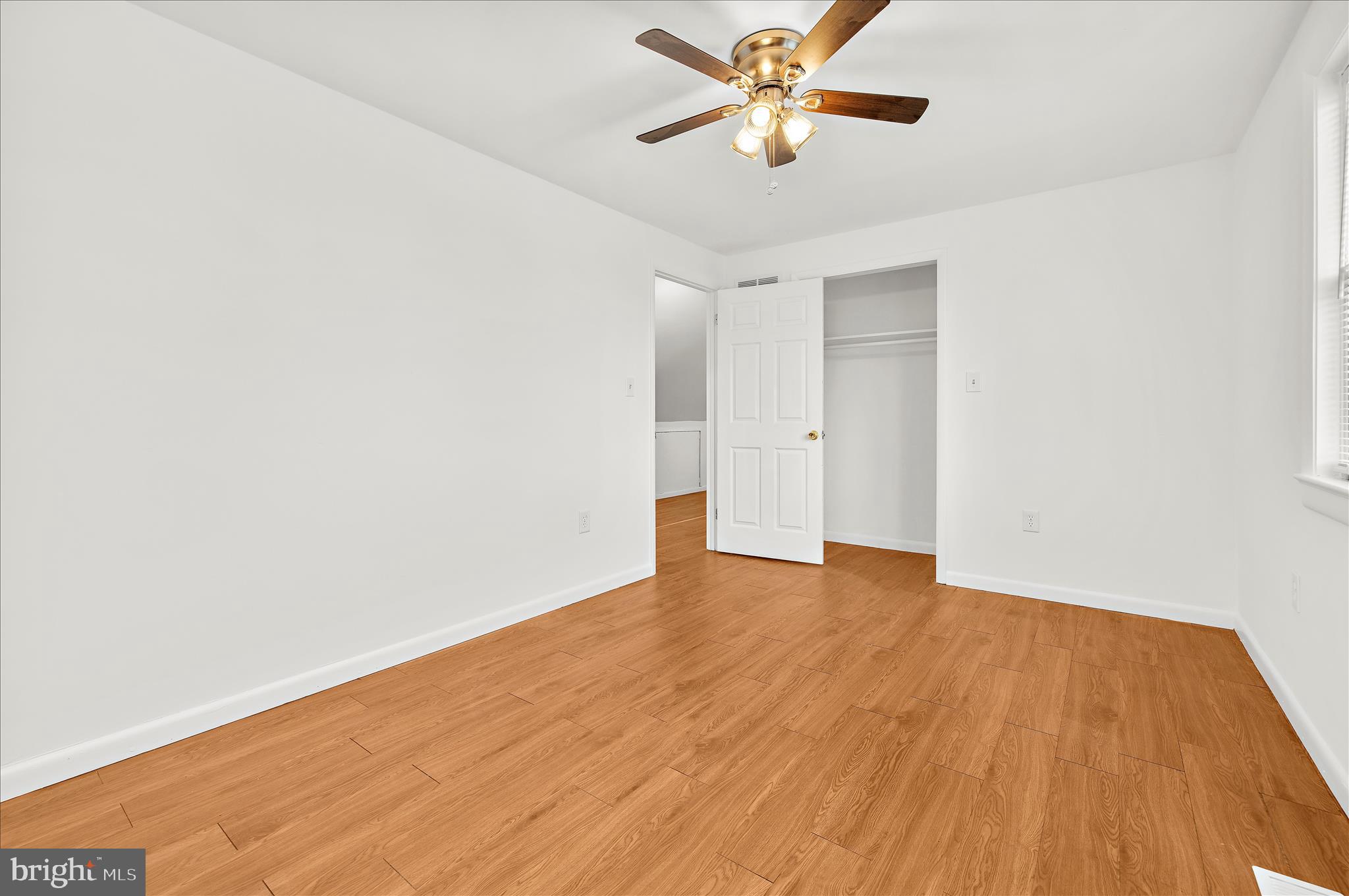 5701 Magie Street Baltimore, MD 21225 - Photo 24 of 49 an empty room with wooden floor and a ceiling fan