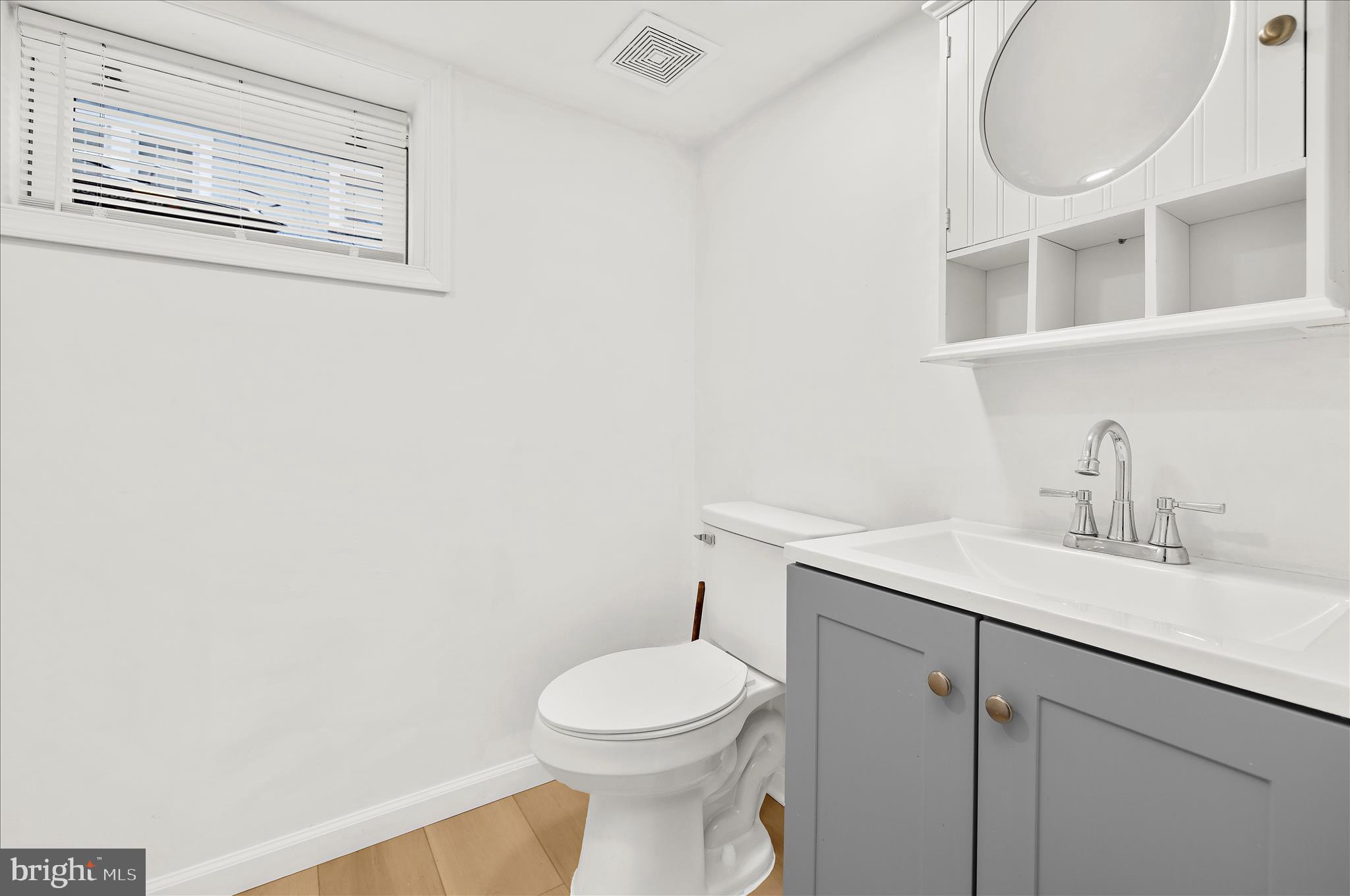 5701 Magie Street Baltimore, MD 21225 - Photo 34 of 49 a bathroom with a toilet a sink and mirror