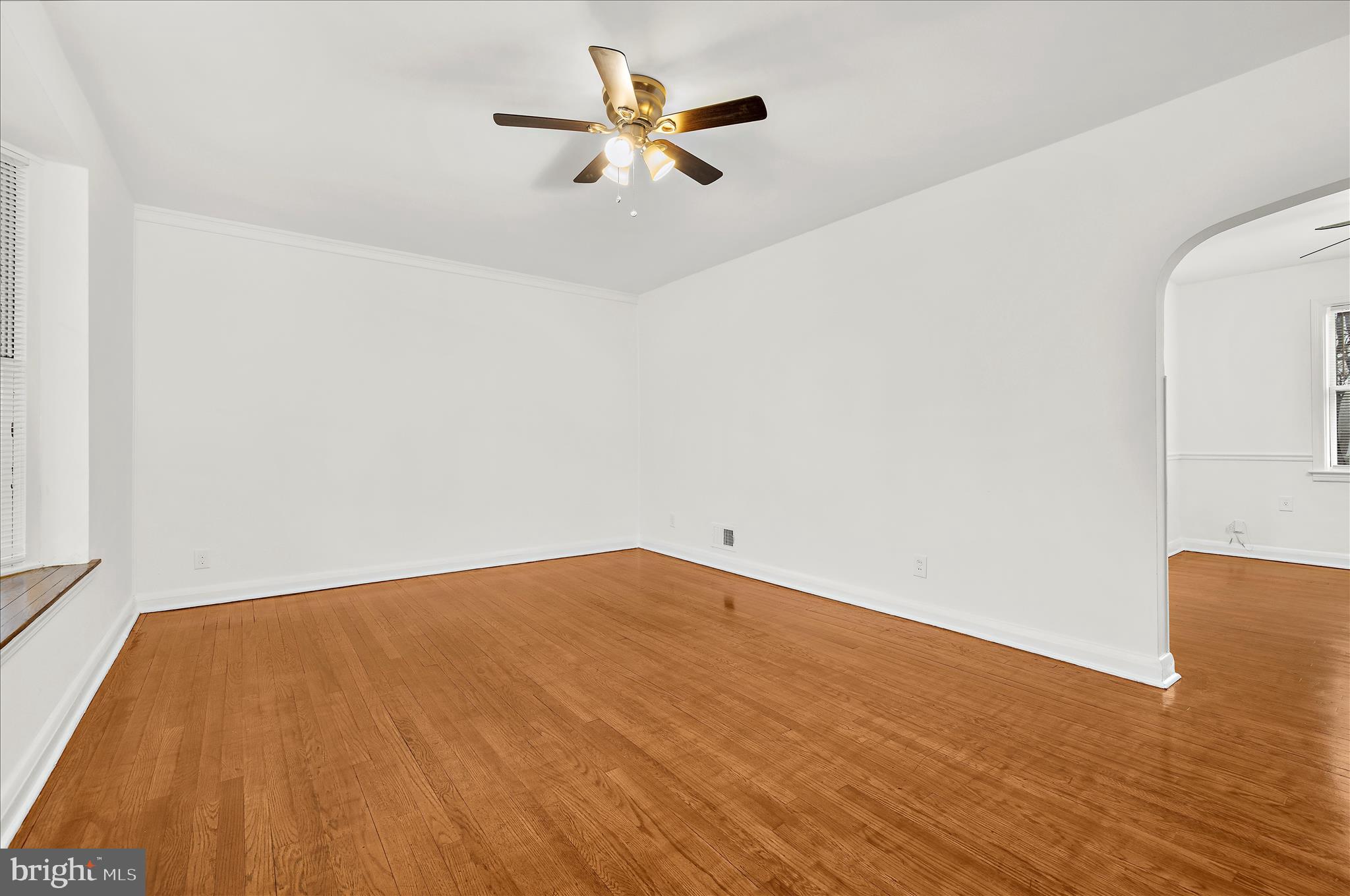 5701 Magie Street Baltimore, MD 21225 - Photo 10 of 49 a view of a big room with wooden floor and a ceiling fan
