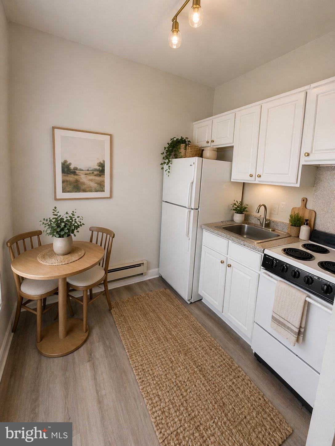5608-00 Ridge Avenue, Unit F4 Philadelphia, PA 19128 - Photo 4 of 5 a kitchen with stainless steel appliances a white table and chairs in it