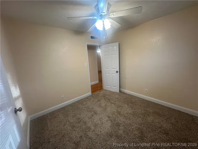 en view of an empty room and chandelier fan