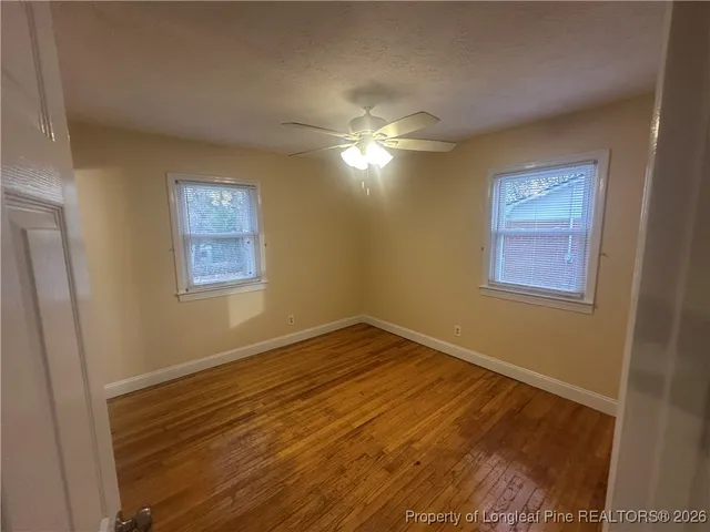 a view of empty room with wooden floor