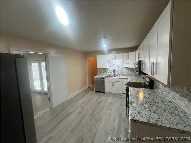 a kitchen with a refrigerator sink and cabinets