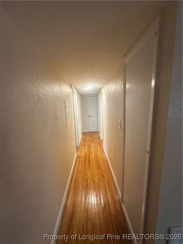 a view of a hallway with wooden floor