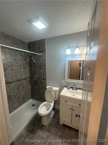 a bathroom with a toilet a sink a mirror a bathtub and shower