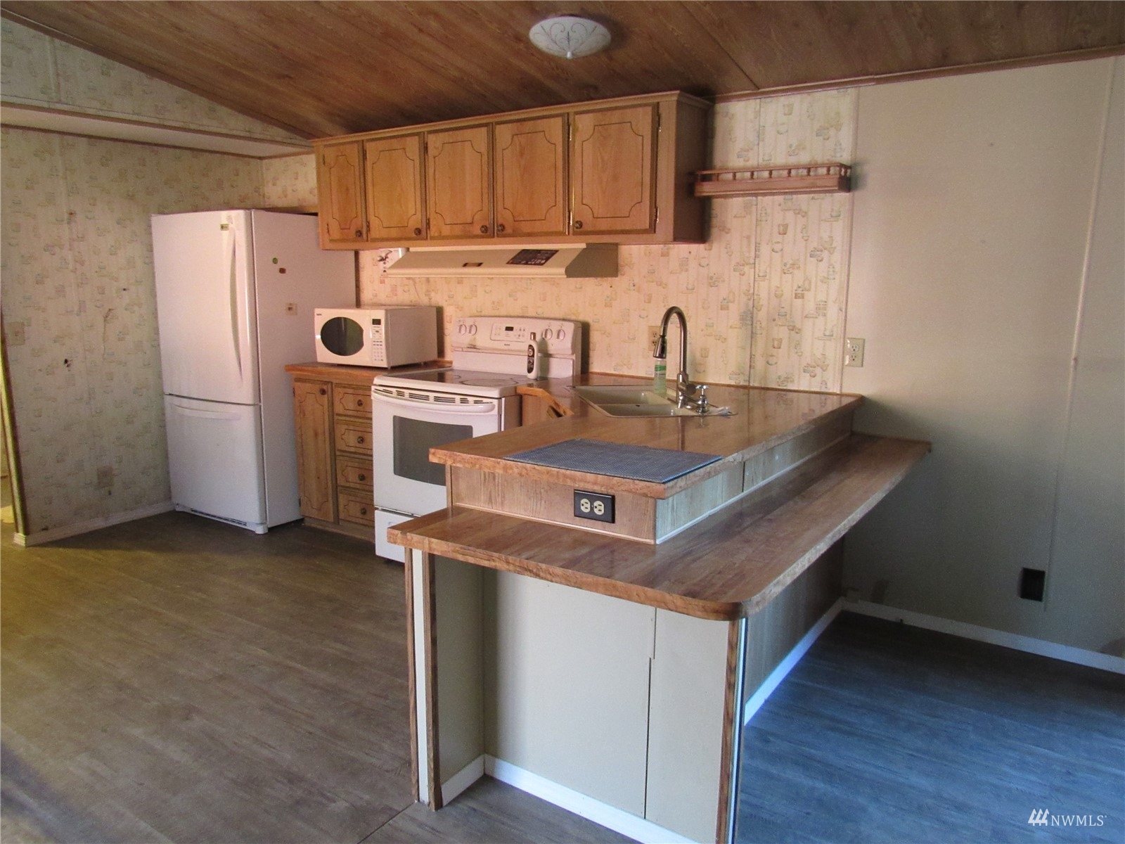 1121 Curtis Street, Unit 18 Sedro-Woolley, WA 98284 - Photo 9 of 20 a kitchen with refrigerator cabinets and wooden floor