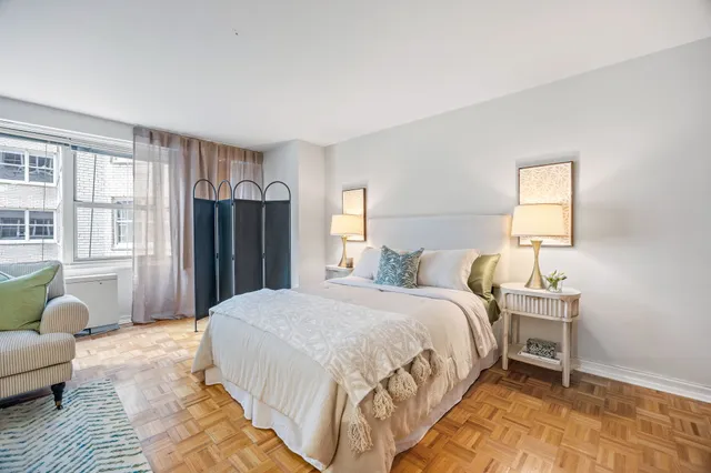 a bedroom with a bed wooden floor and a window