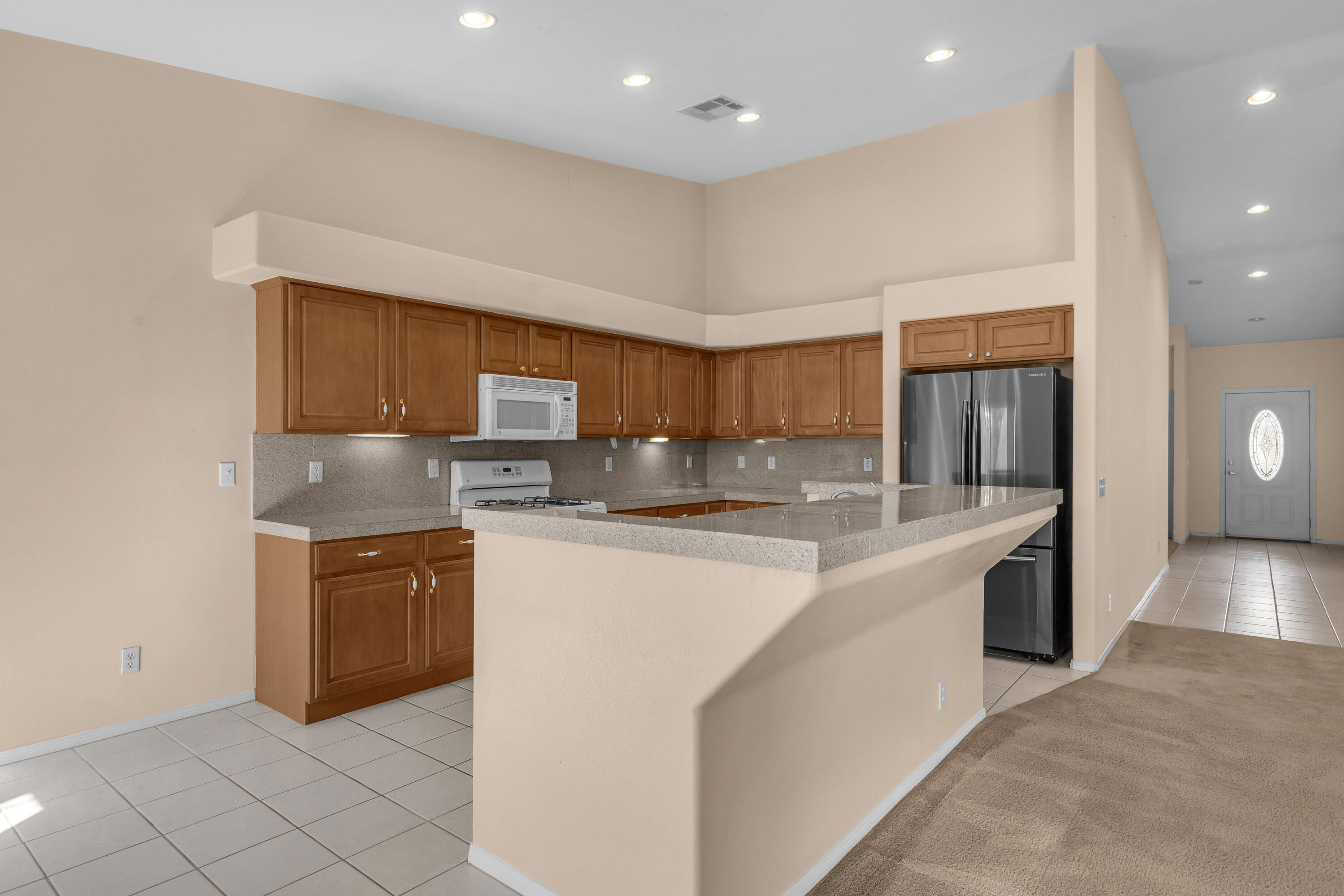 48690 Hepburn Drive Indio, CA 92201 - Photo 16 of 36 a large kitchen with stainless steel appliances granite countertop a sink and cabinets