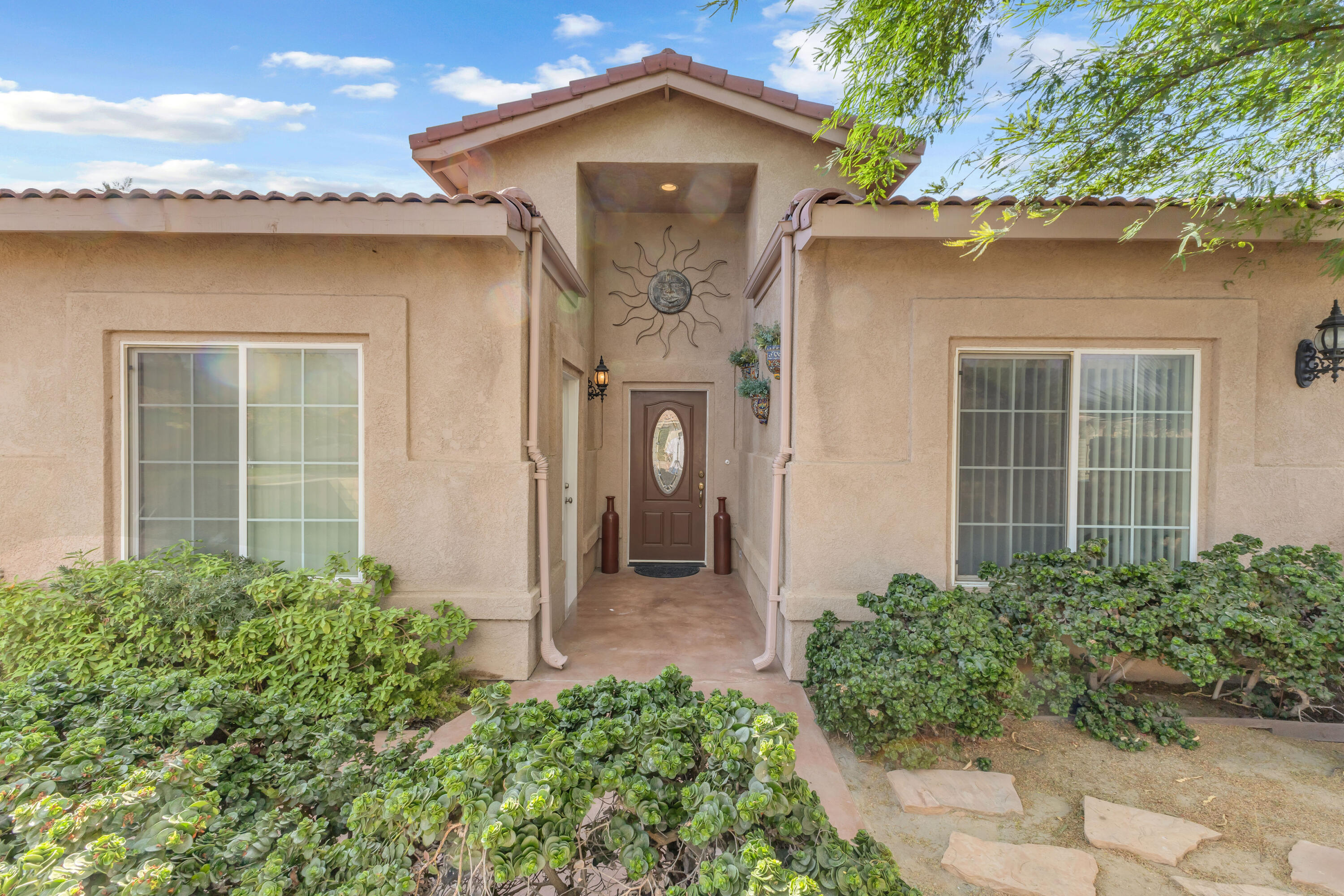 48690 Hepburn Drive Indio, CA 92201 - Photo 3 of 36 a front view of a house with garden