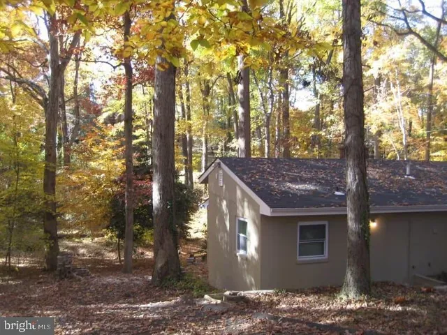 a view of a house with a yard tree and wooden fence
