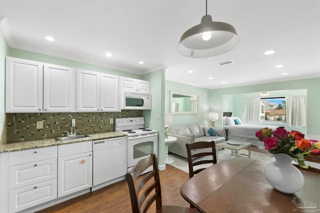 a kitchen with white cabinets and chandelier