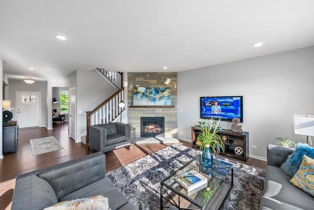 4331 Little Leaf Road Naperville, IL 60564 - Photo 20 of 39 a living room with furniture a fireplace and a flat screen tv